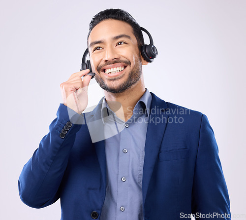 Image of Thinking, customer service and smile with a man consulting using a headset for support in studio on a gray background. Idea, contact us and crm with a happy male consultant talking over a microphone