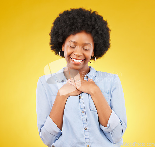 Image of Black woman, happy and self love with hands on chest for gratitude, peace and calm with eyes closed on yellow studio background. Content, wellness and care with mockup space, happiness and heart