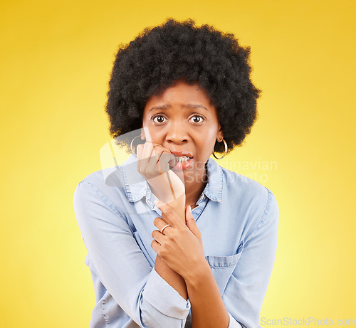 Image of Fear, anxiety and biting nails with portrait of black woman in studio for scared, worry and nervous. Terror, problem and mental health with female on yellow background for stress, confused and crisis