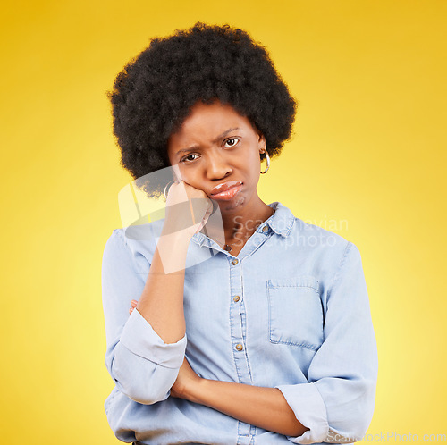 Image of Black woman, sad face and portrait in studio upset, sulking and disappointed on a yellow background. African female model with fatigue, problem or mental health with afro hair and color space
