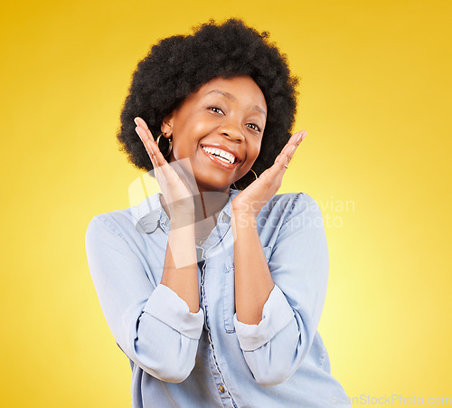 Image of Black woman, hands on face and smile portrait in studio while excited on yellow background. African female model with afro, beauty and happiness on color space with motivation and positive mindset