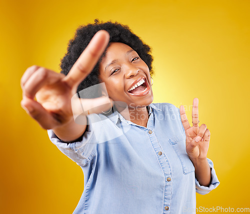 Image of Black woman, peace sign and happy portrait in studio excited, smile and positive on a yellow background. African female model with hand, icon or happiness emoji for freedom, motivation and self love