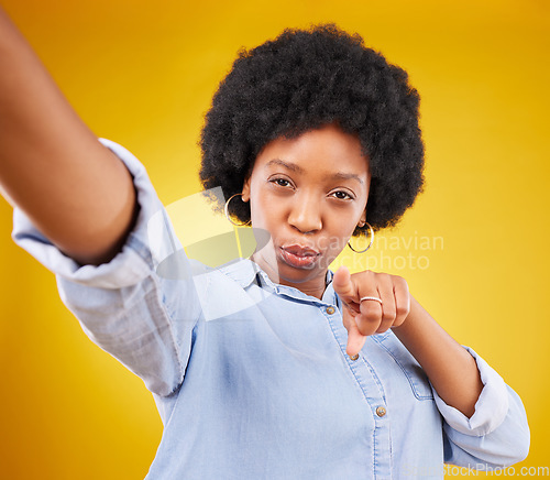 Image of Portrait, selfie and black woman pointing to you in studio isolated on a yellow background. Face, emoji and serious female model taking photo for profile picture or social media with hand gesture.