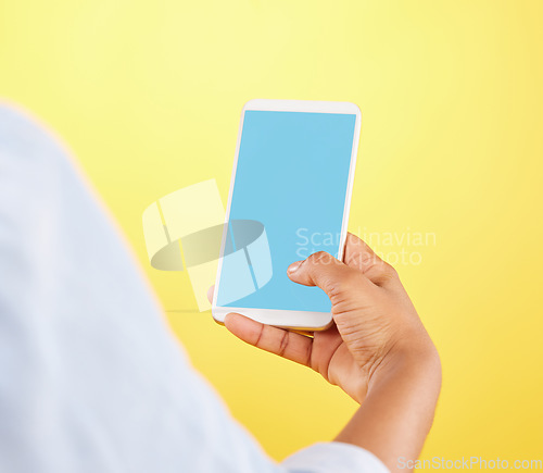 Image of Phone mockup, hands and green screen in studio isolated on a yellow background. Cellphone, social media and black woman typing on smartphone for advertising space, marketing or product placement.