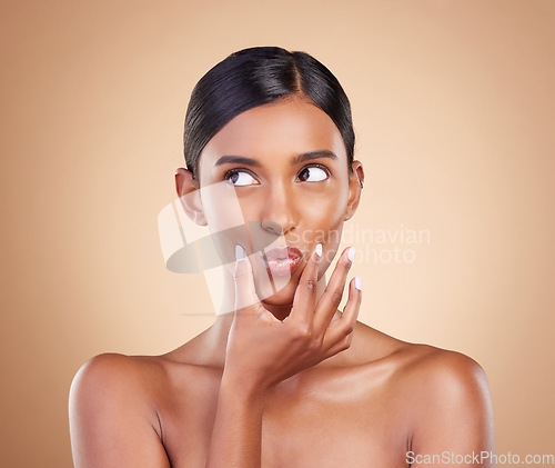 Image of Pout, beauty and Indian woman with skincare, makeup and cosmetic glow and clear skin isolated in a studio brown background. Thinking, self care and face of natural female model with facial routine