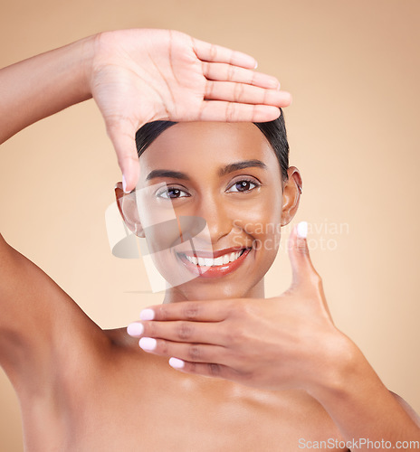 Image of Portrait, hands and frame with a model woman in studio on beige background for beauty or skincare. Face, skin and hand gesture with an attractive young female posing for cosmetics or luxury wellness