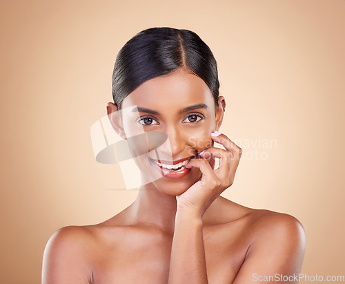 Image of Portrait, beauty and biting finger with a model woman in studio on a beige background for skincare. Face, mouth and flirt with an attractive young female posing for cosmetics or luxury wellness