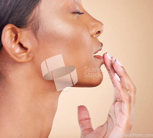 Image of Skincare, touching lips and woman with cosmetics, dermatology and girl against a brown studio background. Female, hand on mouth and lady with makeup, grooming and treatment with smooth and soft skin