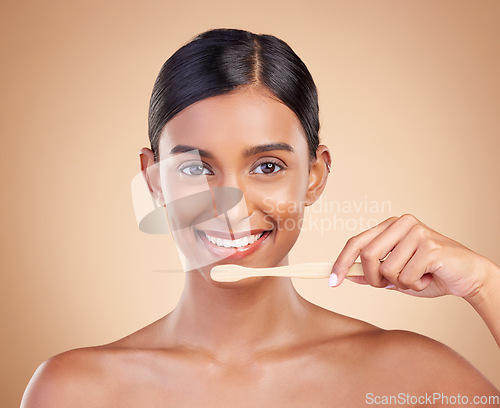 Image of Portrait, dental and toothbrush with a model woman in studio on a beige background to promote oral hygiene. Face, mouth and dentist up with an attractive young female cleaning or brushing her teeth