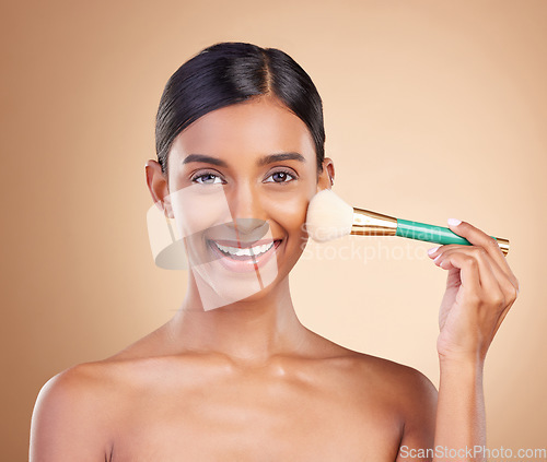 Image of Portrait, beauty and blush with a model woman in studio on a beige background to promote makeup. Face, brush and cheek with an attractive young female posing for cosmetics or luxury wellness