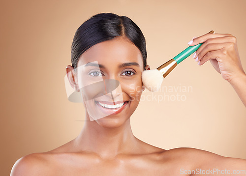 Image of Portrait, beauty and blusher with a model woman in studio on a beige background to promote makeup. Face, brush and cheek with an attractive young female posing for cosmetics or luxury wellness