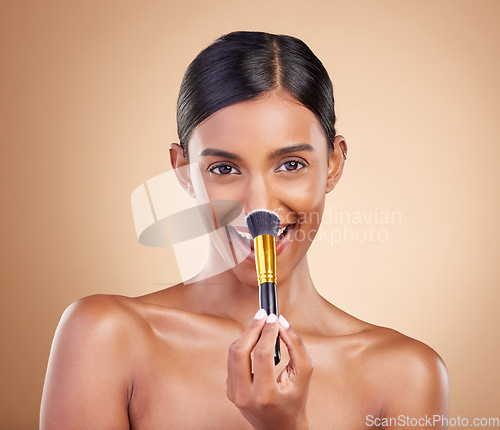 Image of Portrait, makeup brush and blush with a model woman in studio on a beige background to promote beauty. Face, nose and blusher with an attractive young female posing for cosmetics or luxury wellness