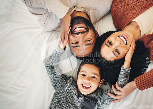 Image of Top view, love and family in bedroom, smile and quality time for joy, bonding and happiness. Portrait, parents and mother with father, boy and male child on bed, cheerful and relax with affection