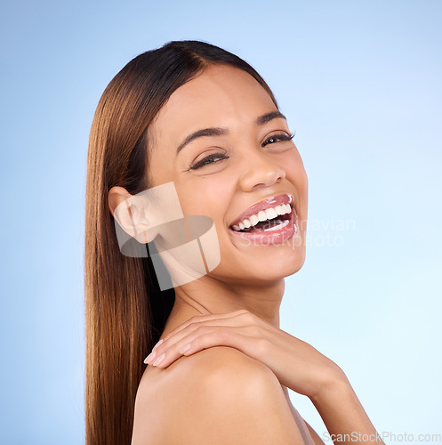 Image of Skincare, hand on shoulder and portrait of woman laughing in studio, skin care on blue background. Makeup, facial detox cosmetics and smile on face, hispanic model with natural beauty for dermatology