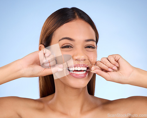 Image of Dental floss, portrait and woman smile with teeth hygiene, healthcare and wellness treatment. Isolated, blue background and studio with a female feeling beauty from a clean mouth with self care