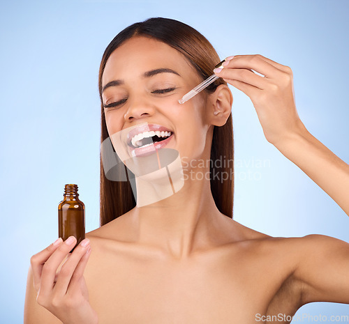 Image of Beauty, skincare and hispanic woman with smile and serum in pipette for anti aging skin glow on blue background. Cosmetics, facial repair and face of model with solution or collagen product in studio