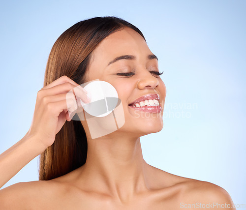 Image of Skincare, woman and cotton pad on face for beauty with dermatology cosmetics in studio. Female model on a blue background for self care, facial glow and healthy or natural skin with detox results