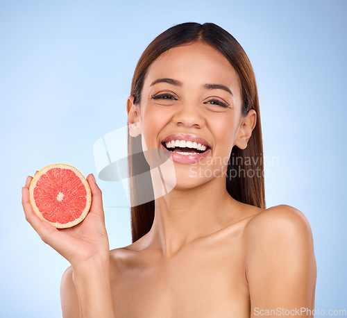 Image of Skincare, beauty and woman with a grapefruit portrait in studio with a healthy and natural face. Happy, wellness and model with dermatology facial treatment wth vitamin c and fruit on blue background