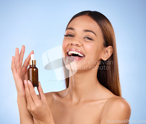 Image of Beauty, skincare and hispanic woman holding serum with smile for anti aging skin glow on blue background. Cosmetics, facial repair and face of model with solution or collagen product in studio promo.