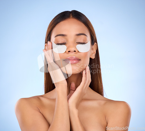 Image of Skincare, beauty and woman with collagen eye mask for anti aging skin glow on blue background. Cosmetics, facial repair pads and face of model with product and in studio for wrinkle treatment.