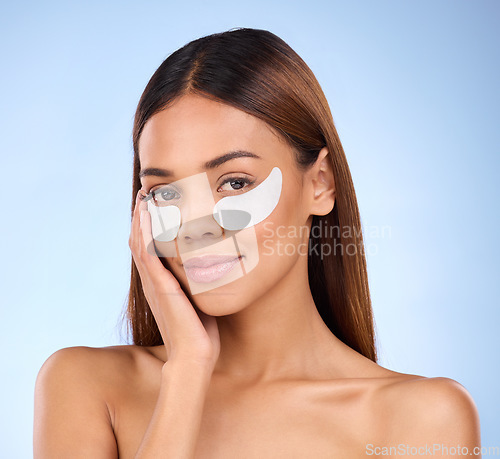 Image of Skincare, collagen pads and portrait of woman with eye mask for anti aging skin glow on blue background. Cosmetics, facial repair and face of beauty model with wrinkle treatment product in studio.