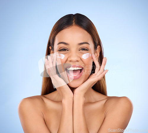 Image of Skincare, dermatology and portrait of happy woman with eye cream for anti aging skin care glow on blue background. Cosmetics, facial and face of hispanic beauty model with product in studio promotion