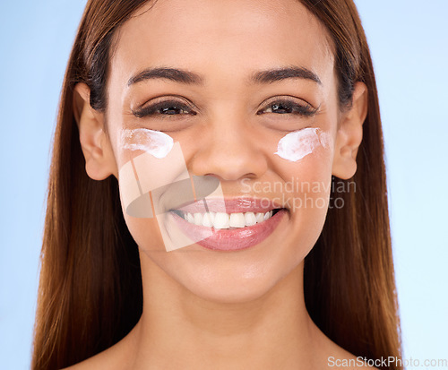 Image of Skincare, eye cream and fresh face of happy woman with anti aging skin care beauty treatment on blue background. Cosmetics, facial and portrait of hispanic model with collagen product in studio promo