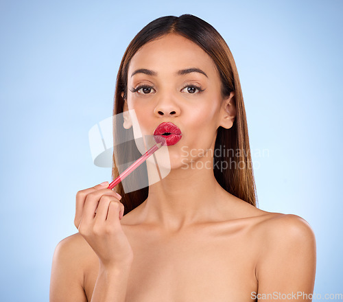 Image of Woman, beauty and red lipliner or lipstick portrait for lips with cosmetics on face in studio. Aesthetic female model on blue background for self care, facial glow and pencil application for skin