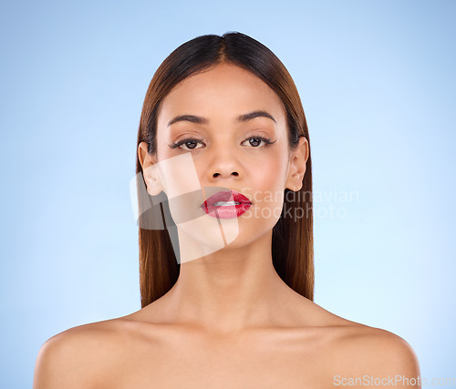 Image of Makeup, woman and red lipstick beauty portrait with cosmetics on face in studio. Aesthetic female model person on a blue background for self care, facial glow and shine or color for skin and wellness