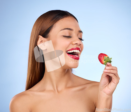 Image of Beauty, health and strawberry with woman in studio for nutrition, diet and detox. Organic food, natural cosmetics and self care with girl model eating fruit on blue background for wellness and glow