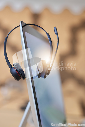 Image of Call center headset, computer and nobody in empty office for telecom, virtual communication or telemarketing background. Callcenter business with desktop screen or pc for online customer services