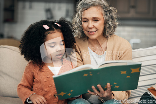 Image of Adoption child, book and grandmother reading fantasy storybook, story or bonding on home living room sofa. Family love, grandma and senior woman with youth development for learning kindergarten girl