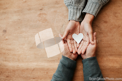 Image of Hands, heart and shape for love, support or care above in trust, unity or compassion together on mockup table. Top view of hand holding for family generation, hope or symbol in bonding relationship