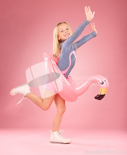 Image of Playing, excited and portrait of girl and pool float for swimming, sea and summer. Youth, funny and inflatable with child and flamingo ring for relax, cute or beach holiday on pink background studio