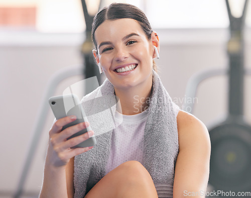 Image of Gym, smile and relax, woman with phone and earphones on workout break reading messages or social media. Exercise, rest and person with smartphone for fitness app, music or networking for motivation.