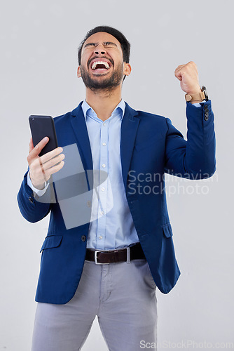 Image of Winner, excited and phone with man in studio for good news, success and bonus. Pride, yes and celebration with male and cheering isolated on gray background for achievement, pride and job promotion