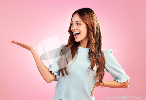 Image of Young woman show palm isolated on pink background for product placement in beauty and fashion lifestyle. Biracial person or model hand holding empty space for promotion, sale and studio mockup