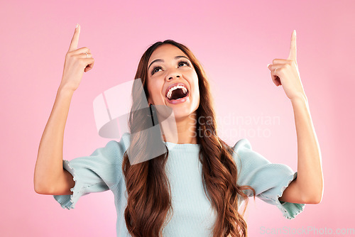 Image of Pointing, mockup and woman on pink background with happy, smile and excited for sale, deal or discount news. Advertising, hands and girl looking up for product placement, promotion and announcement