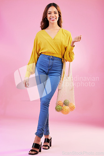 Image of Portrait, shopping and woman nutritionist with fruit in studio for health, diet and healthy living on pink background. Face, groceries and happy girl customer with organic product, nutrition or detox