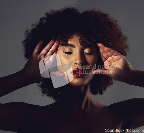 Image of Dark, beautiful and face of a woman with makeup isolated on a black background in a studio. Stunning, glow and girl showing cosmetics, glamour and beauty, elegance and classy look on a backdrop