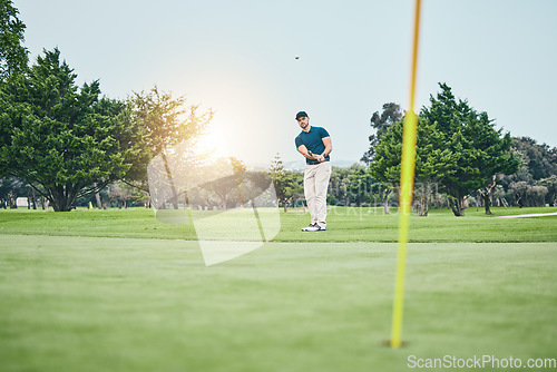Image of Grass, golf hole and man with golfing club on course for game, practice and training for competition. Professional golfer, sports and male athlete hit ball with club for winning, score or tee stroke