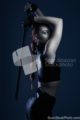 Image of Fighter, dark and portrait of woman with a weapon isolated on a black background in a studio. Mystery, superhero and an assassin, ninja or girl doing cosplay, warrior fashion and acting on a backdrop
