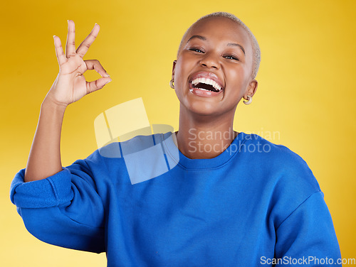 Image of Portrait, laughing and black woman with ok sign in studio isolated on a yellow background. Success, emoji face and happy, comic and funny female with hand gesture for okay, support or perfection.