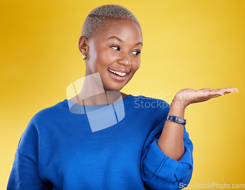 Image of Mock up, smile and black woman with product placement in studio isolated on a yellow background. Mockup promotion, happy and African female with palm for advertising, marketing and branding space.