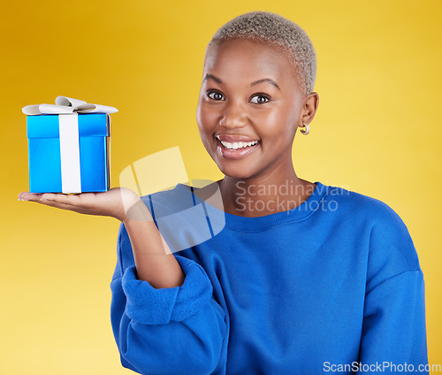 Image of Smile, portrait and black woman with gift in studio isolated on a yellow background. Face, box and happy African female with present for celebration, party and holiday, birthday and special event.