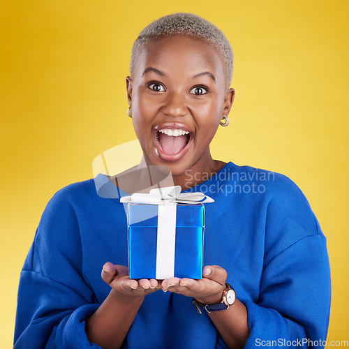 Image of Excited, portrait and black woman with birthday gift in studio isolated on a yellow background. Face, box and happy African female with present for celebration, party and holiday for special event.