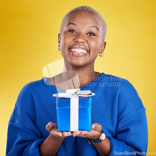 Image of Portrait, smile and black woman with birthday gift in studio isolated on a yellow background. Face, box and happy African female with present for celebration, party and holiday for special event.