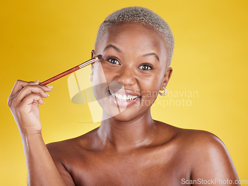 Image of Beauty, cosmetics and portrait of black woman with brush in hand in studio and skincare isolated on yellow background. Happy makeup routine, eye shadow and smile, face of model with luxury product.