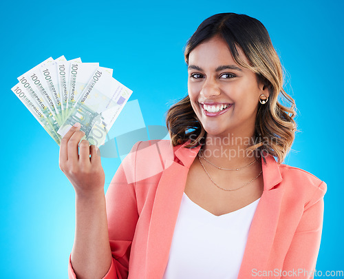 Image of Portrait, smile and business woman with euros in studio isolated on a blue background. Financial winner, face and happy Indian female with cash money after winning lottery, prize and competition.