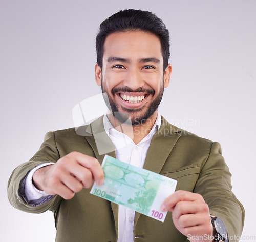 Image of Portrait, money and euro with a business man in studio holding cash on a gray background for finance. Smile, accounting or investment with a happy male employee proud of his financial trading success